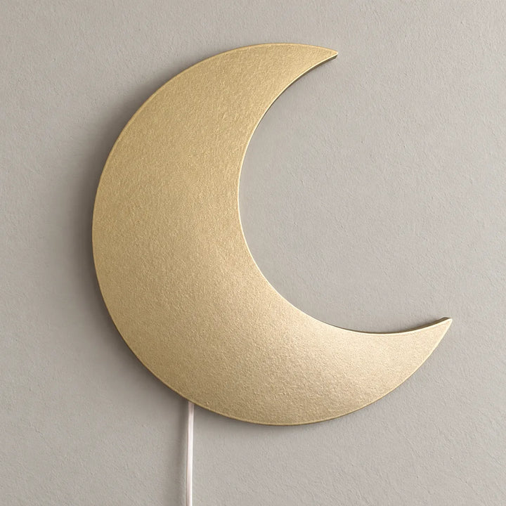 Houten golden crescent wall lamp shown unlit on a bedroom wall