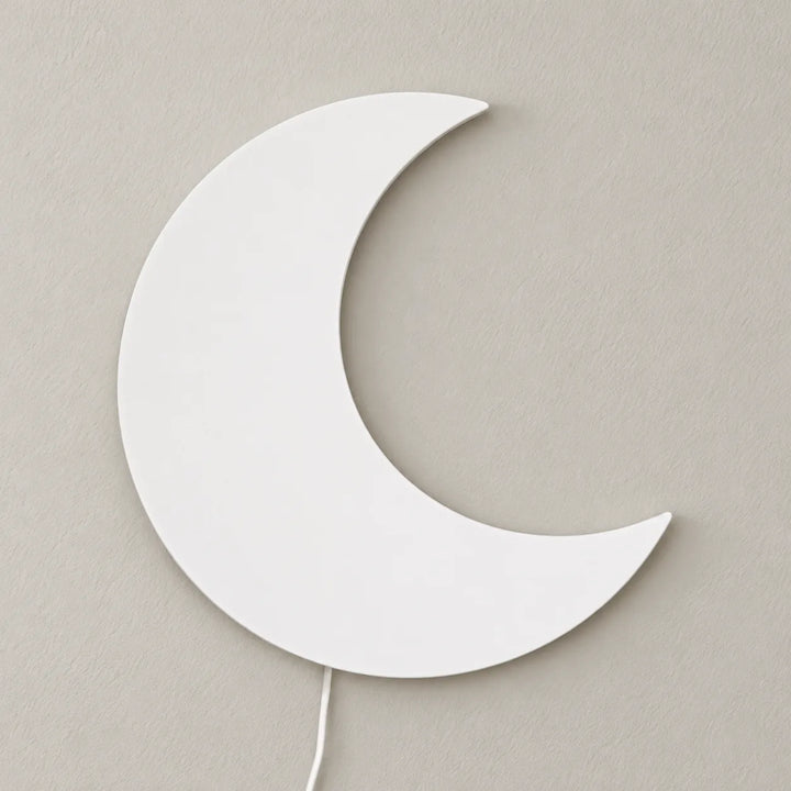 Houten white crescent wall lamp shown unlit on a bedroom wall