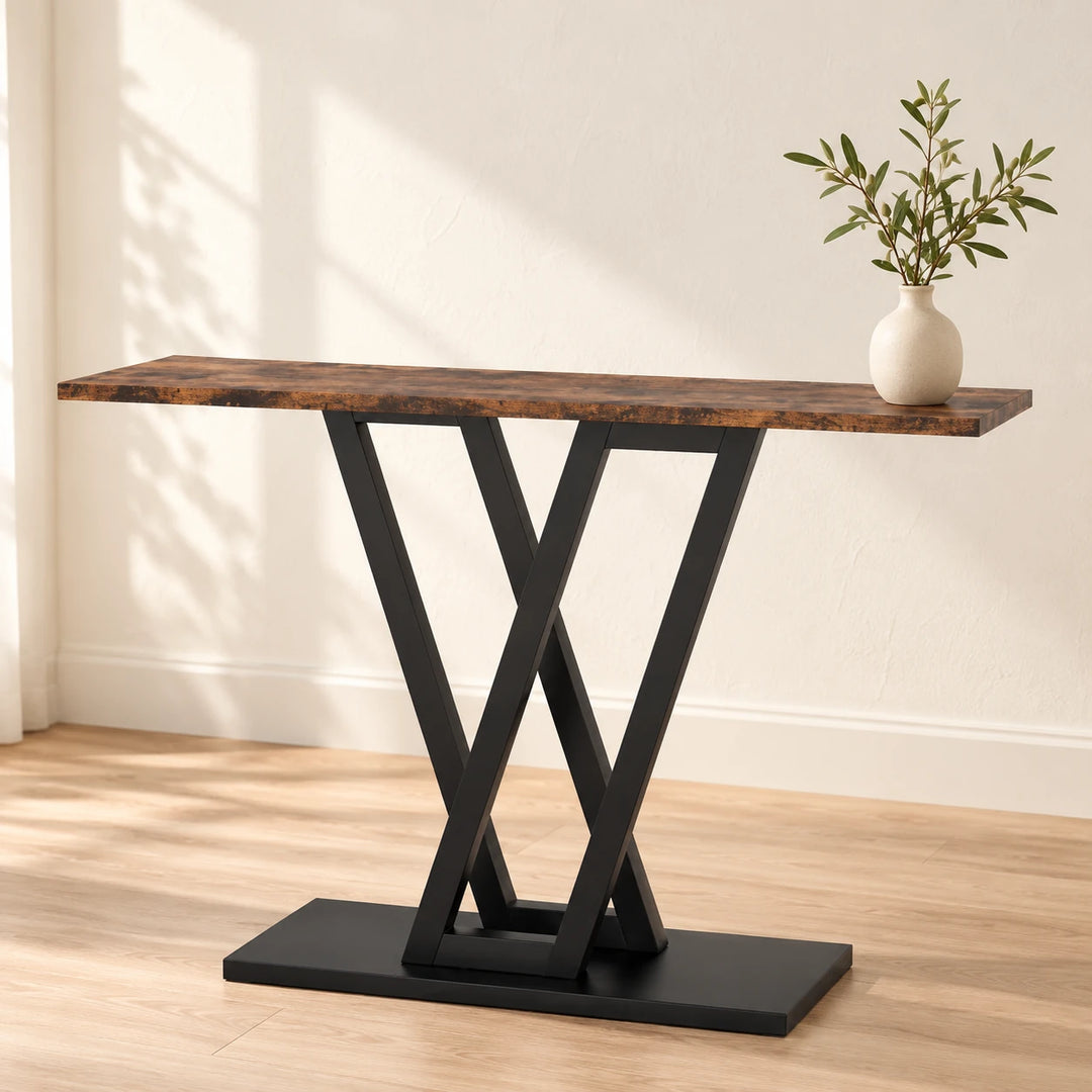Kadenn rustic brown console table with black crossed V-shaped metal supports in a sunlit entryway