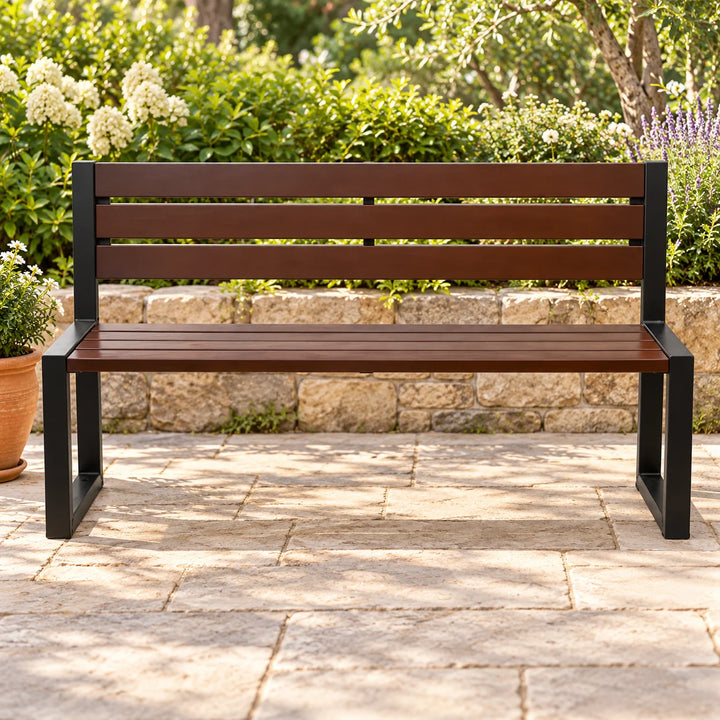 Karozin dark brown garden bench with black frame in a leafy garden