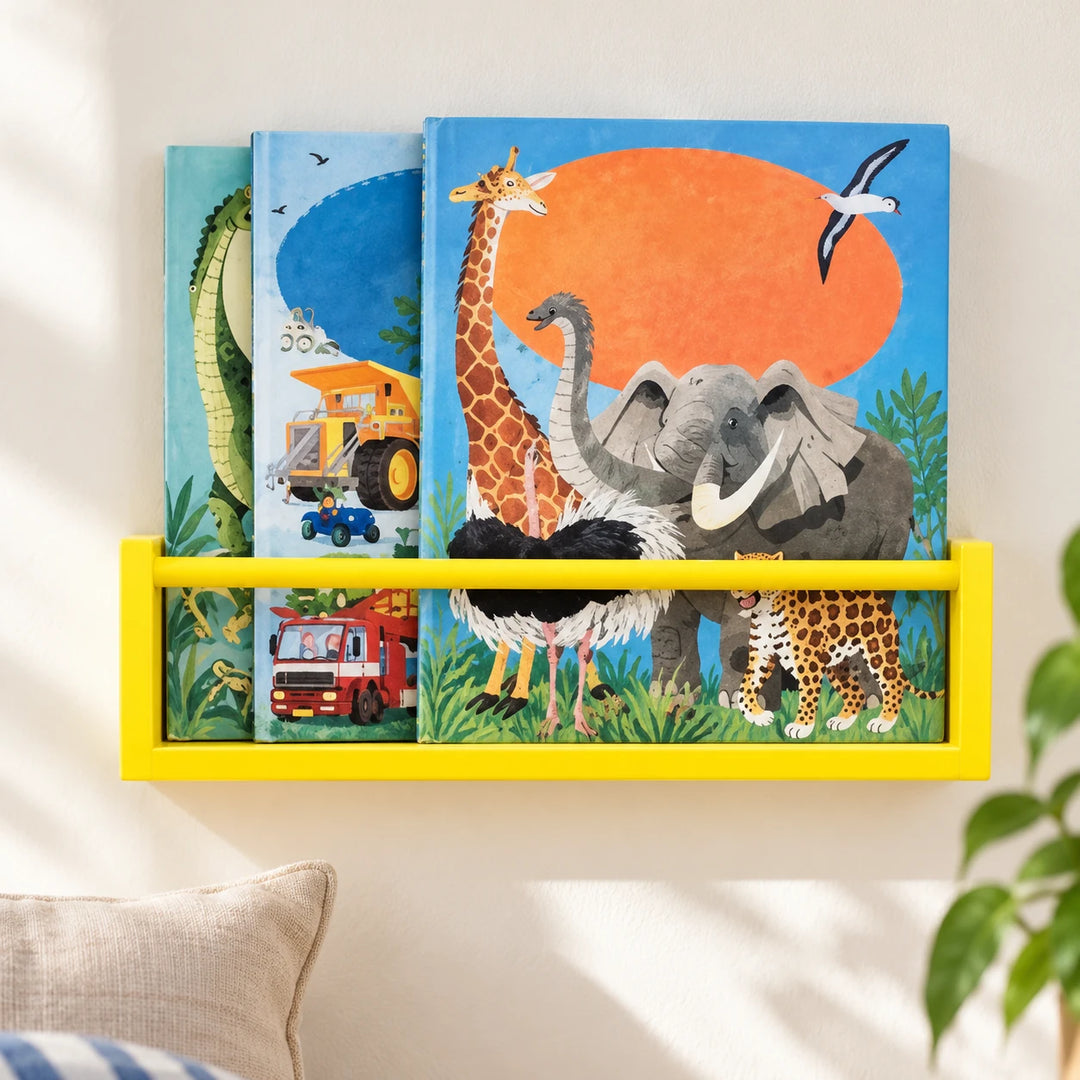 Yellow kids wall-mounted book shelf with one round retaining rail and picture books in a sunlit room