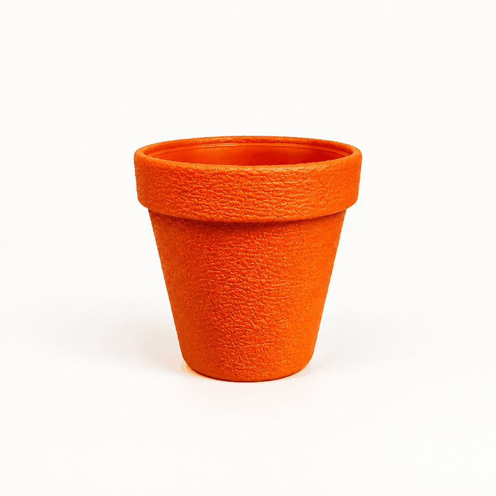 Large orange textured planter pot, empty, on plain white background