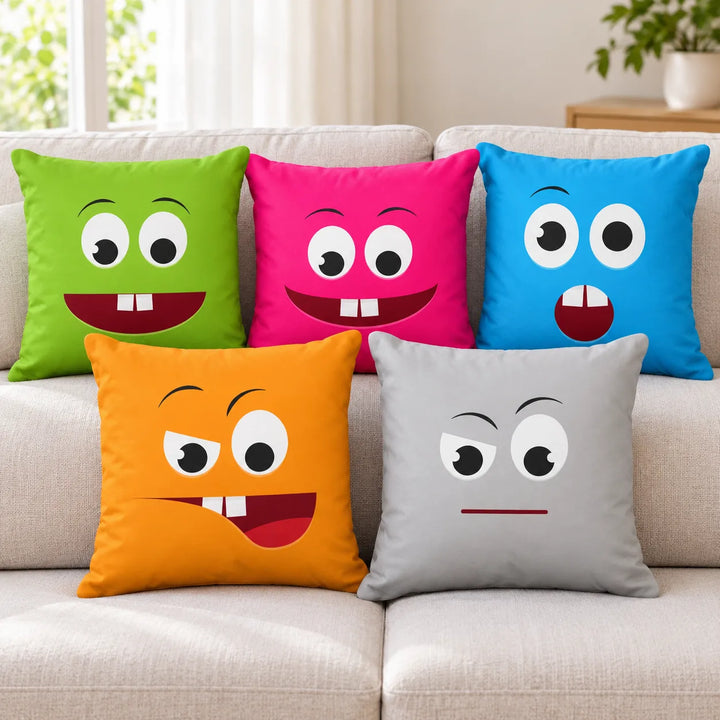 Five Laugh Moobs cushion covers in green, pink, blue, orange and grey with their original face prints, arranged on a sofa