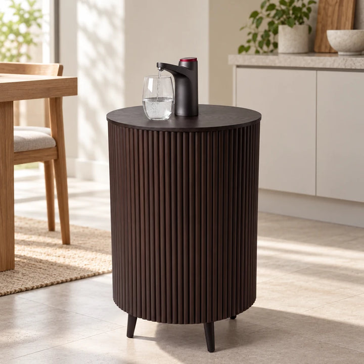 Brown fluted cylindrical Lumo Grid water bottle rack in a neutral room with existing dispenser and glass