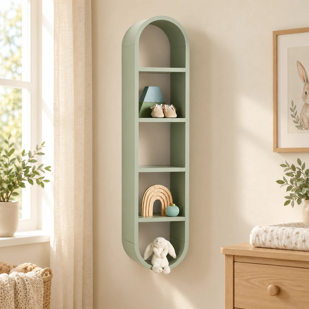Tall sage green oval wall shelf with five compartments in a softly lit nursery corner
