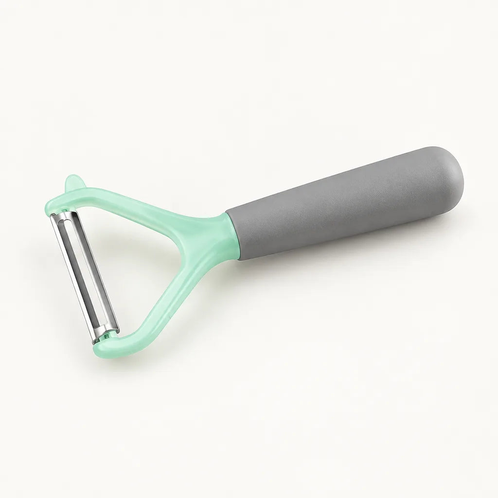 Vegetable peeler slicer with grey handle and mint green head on white background