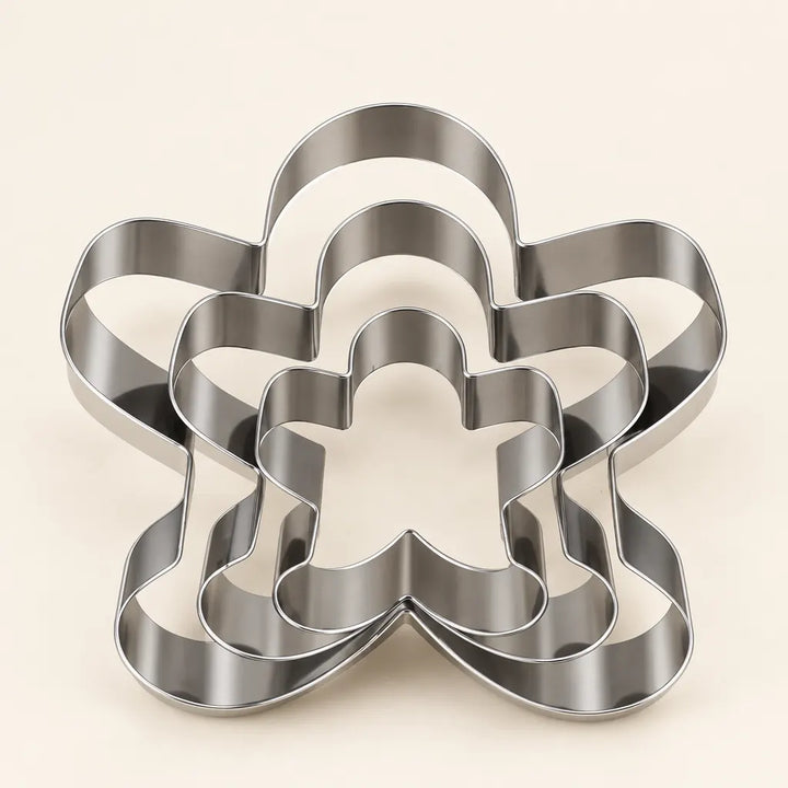 Set of three stainless steel cookie baking moulds nested together on white background