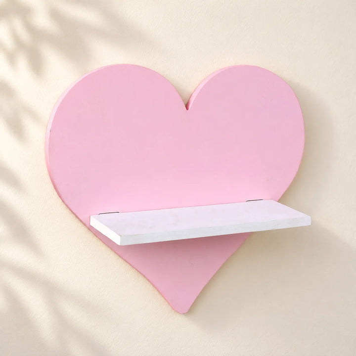 One pink heart-shaped Nordic wall shelf with white shelf, shown mounted on an ivory wall