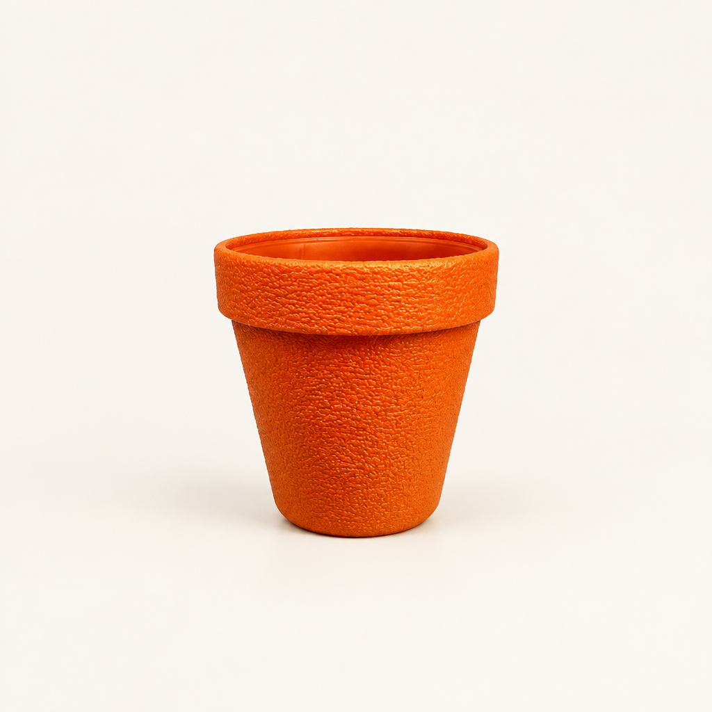 Extra large orange plant pot with textured surface on plain cream background