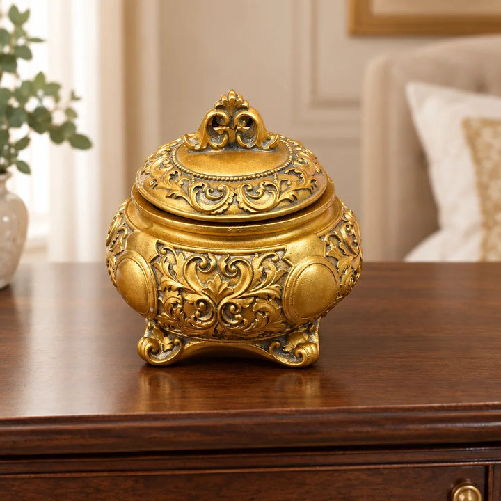 Ornate golden storage box with bow knot lid and floral carved body, close-up