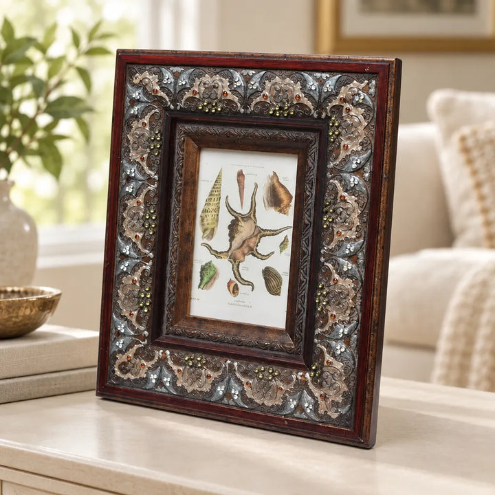 Dark red photo frame with patterned mosaic border on wooden table