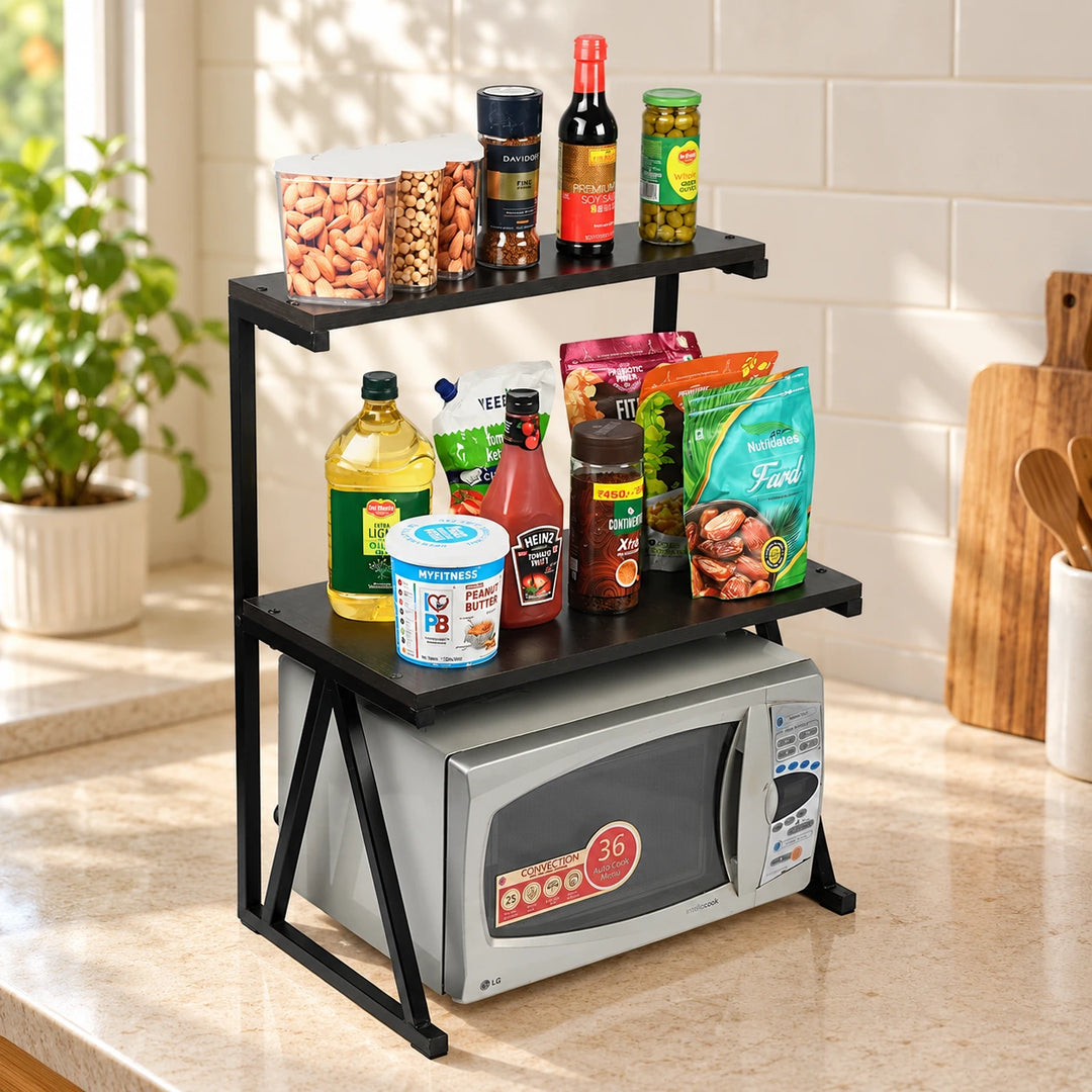 Black two-tier microwave and pantry organizer rack in a naturally lit kitchen