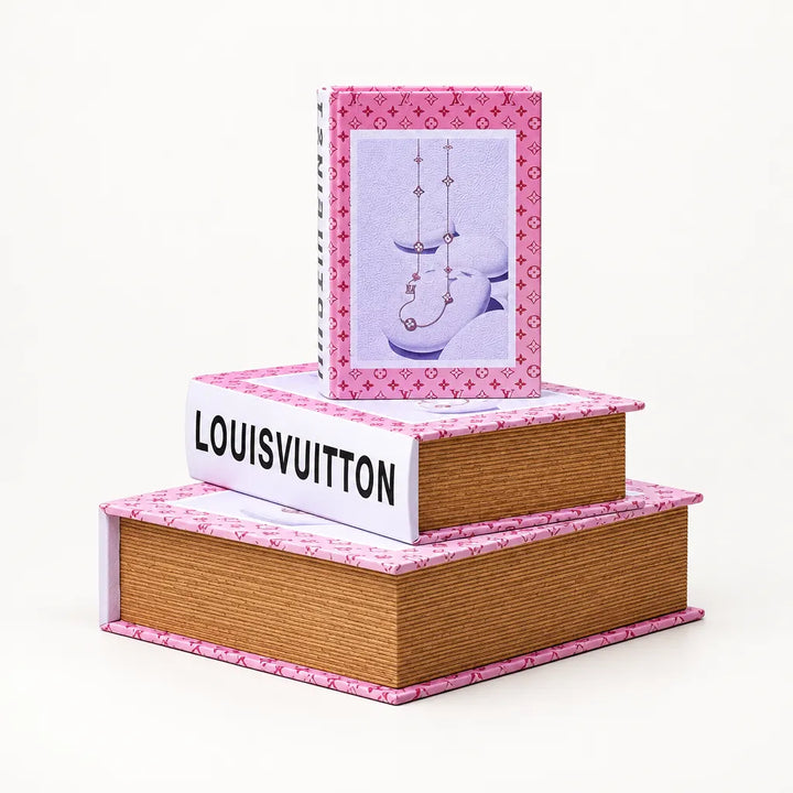 Set of three pink trimmed book decor boxes stacked on white background, front view