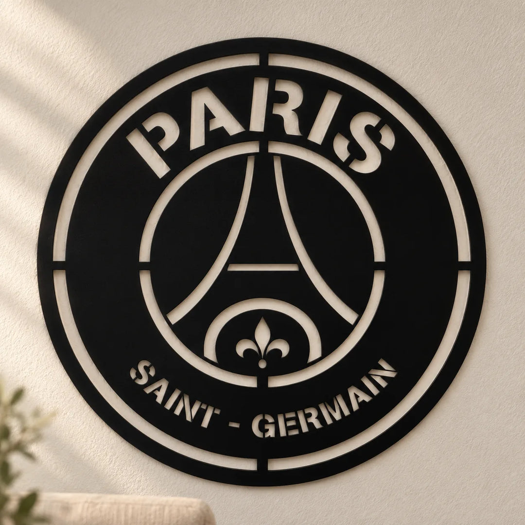 Black Paris Saint-Germain MDF crest wall decor on a warm textured wall, showing its original stencil lettering and cutout pattern.