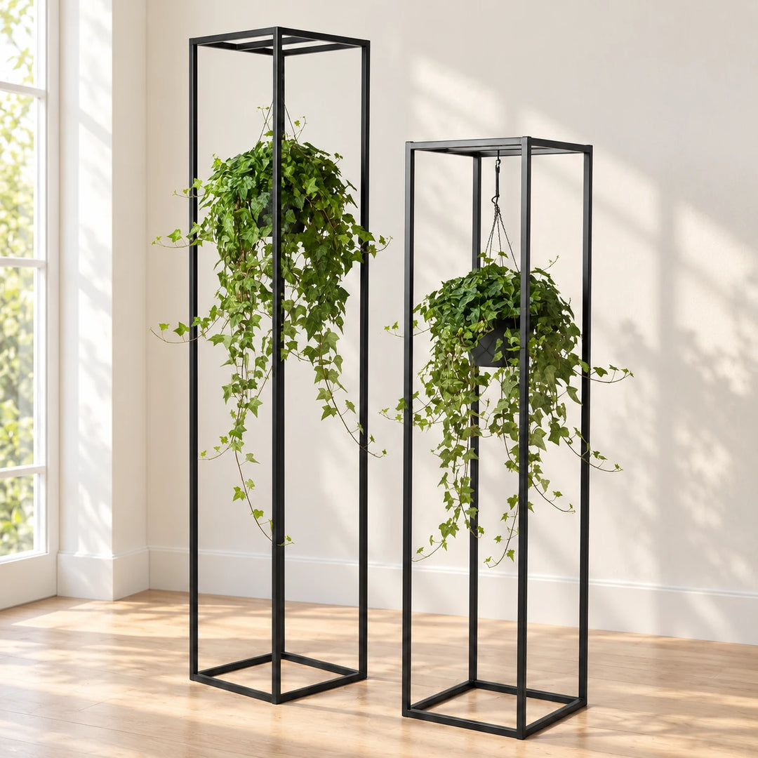 Two Reetala black plant stands of different heights shown with hanging plants by a window
