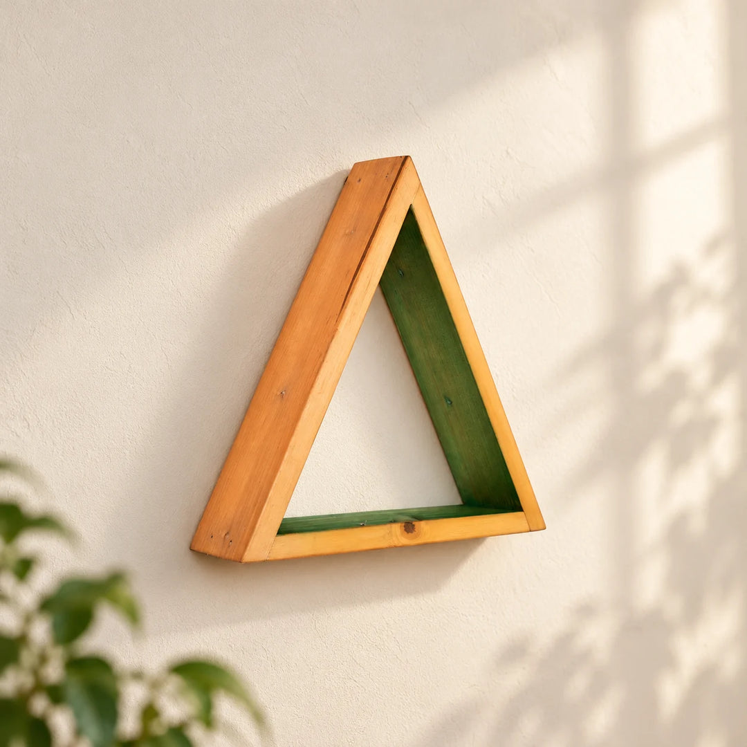 Single triangular natural-wood wall shelf with green inner surfaces on a softly lit neutral wall