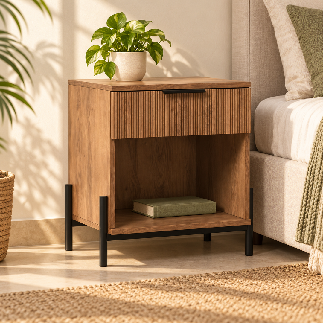Single brown Ridvan nightstand with fluted drawer and open cubby beside a bed