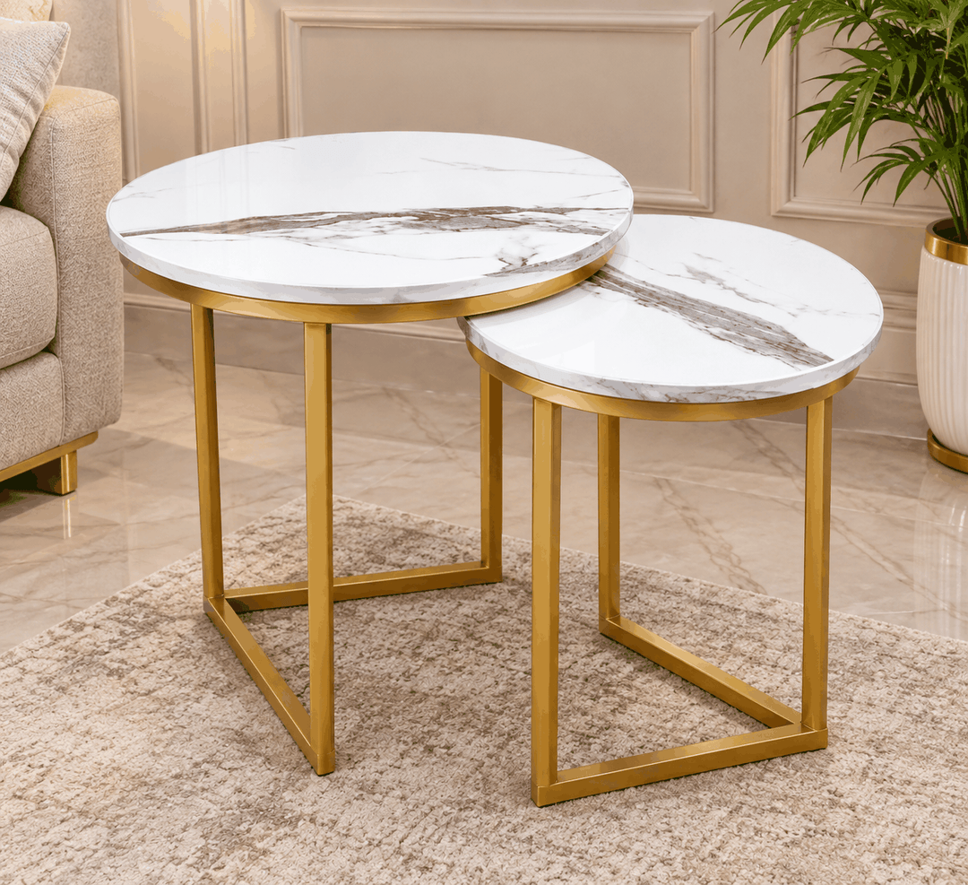 White marble top nesting coffee tables with gold frames on beige rug