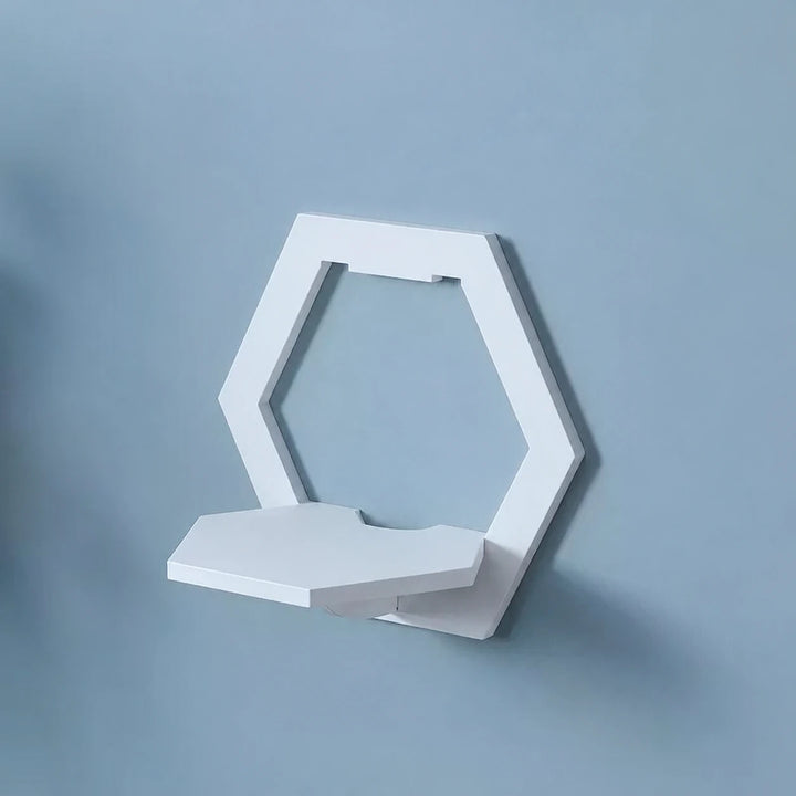 One white hexagonal wall-mounted shelf on a blue-grey wall