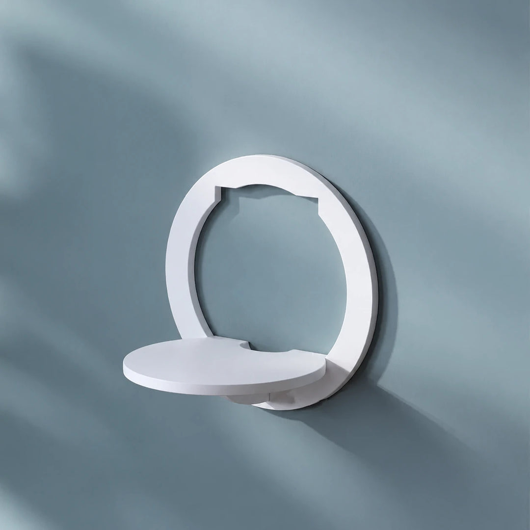 One white round wall-mounted shelf on a blue-grey wall