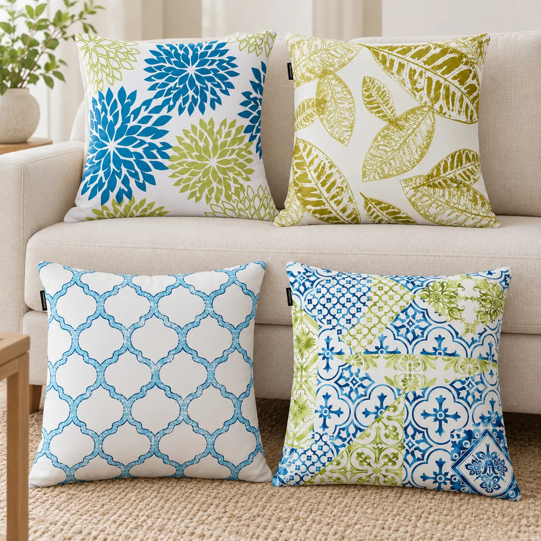 Set of four Seravia blue and green floral, leaf, trellis and patchwork cushion covers styled on a sofa and rug; fillers not included.