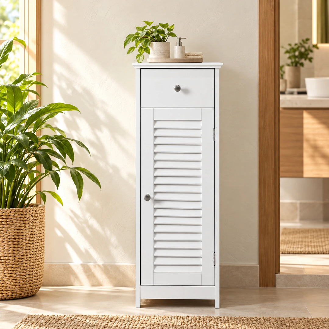 White narrow shutter-door floor cabinet with top drawer in a warm sunlit bathroom nook