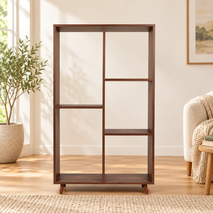 Walnut open bookcase with five asymmetrical compartments in a calm reading nook beside a natural plant