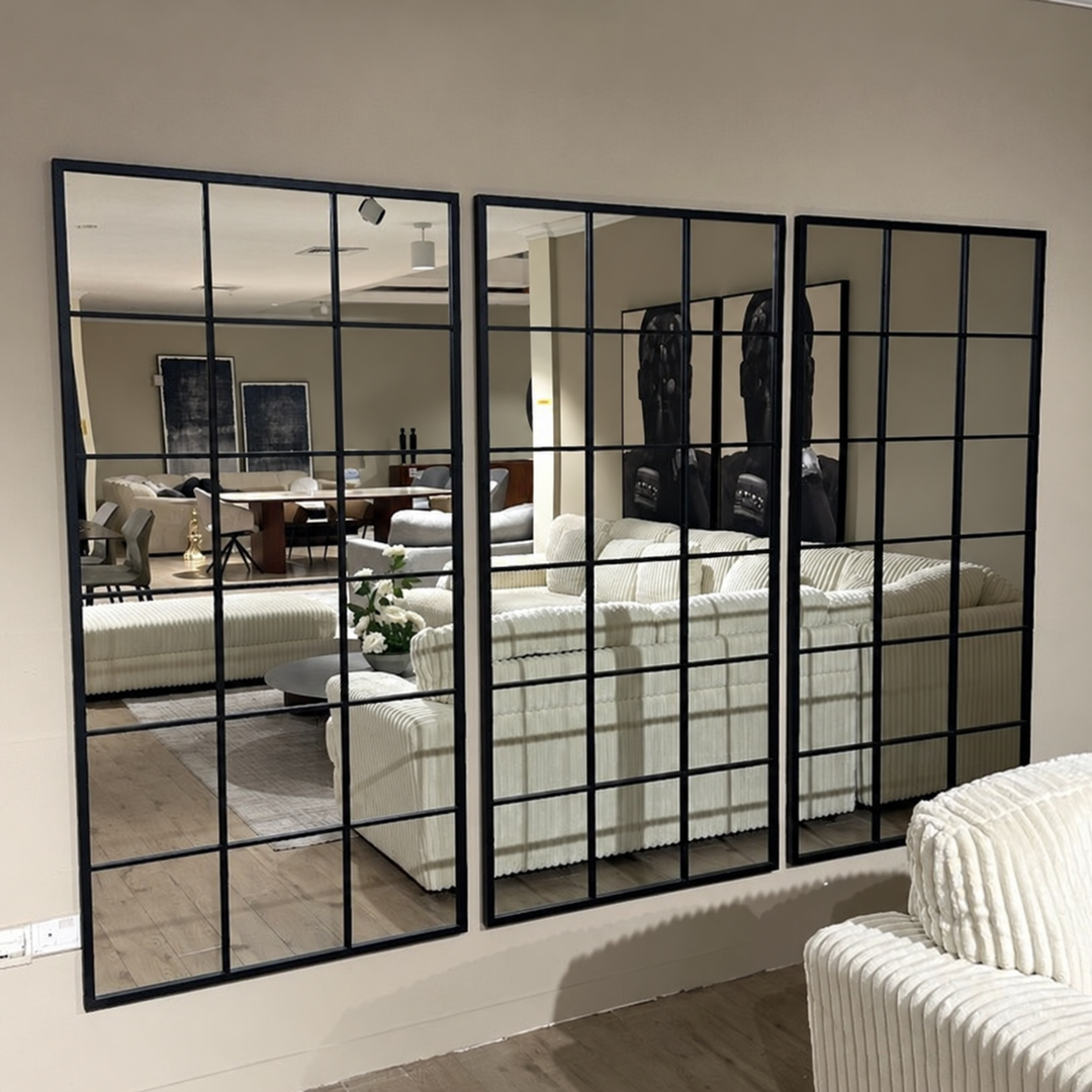 Sisiac set of three black grid-panel wall mirrors with showroom reflections and foreground chair