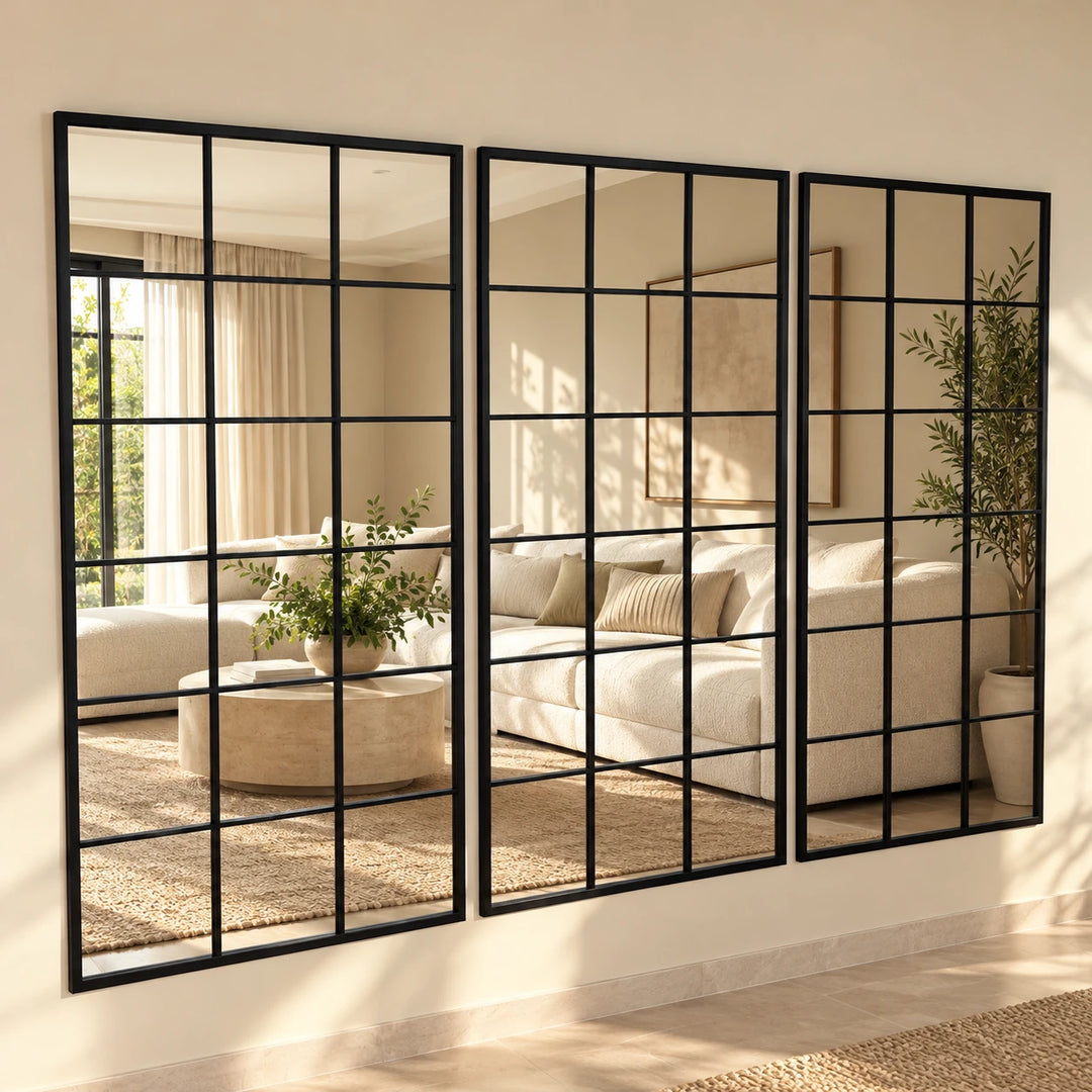 Set of three Sisiac black grid-panel wall mirrors reflecting a warm daylight lounge with neutral sofa and greenery