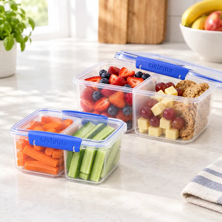 Clear divided food containers with blue clips holding fruit and vegetables