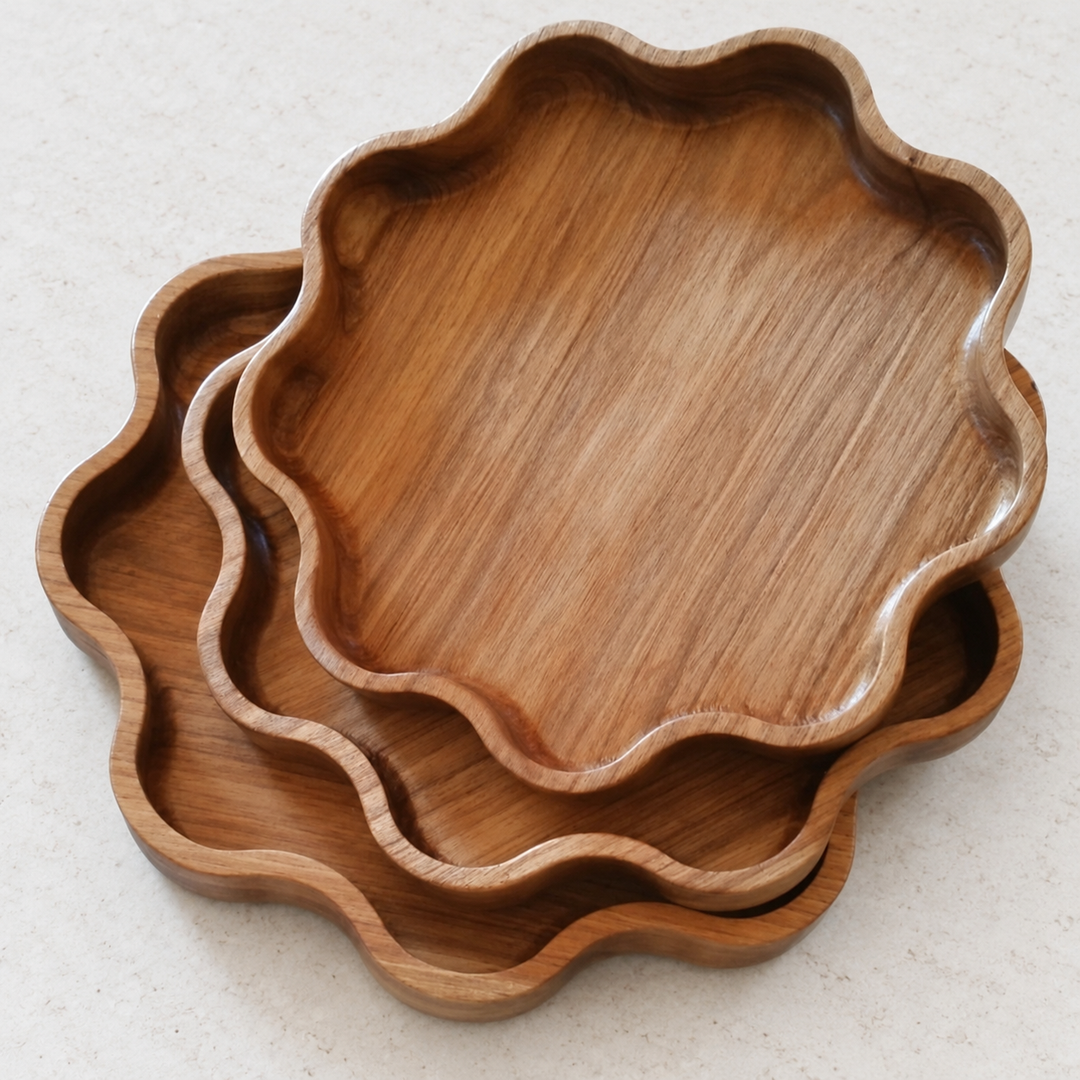 Three nested scalloped wooden Star serving trays on a neutral light tabletop