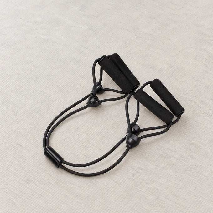 Black Straps Body Shaper exercise device on a light neutral surface