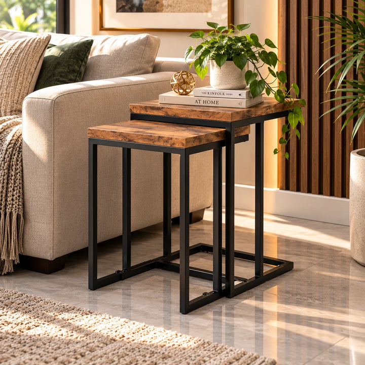 Two rectangular nesting side tables with brown tops and black frames beside a sofa