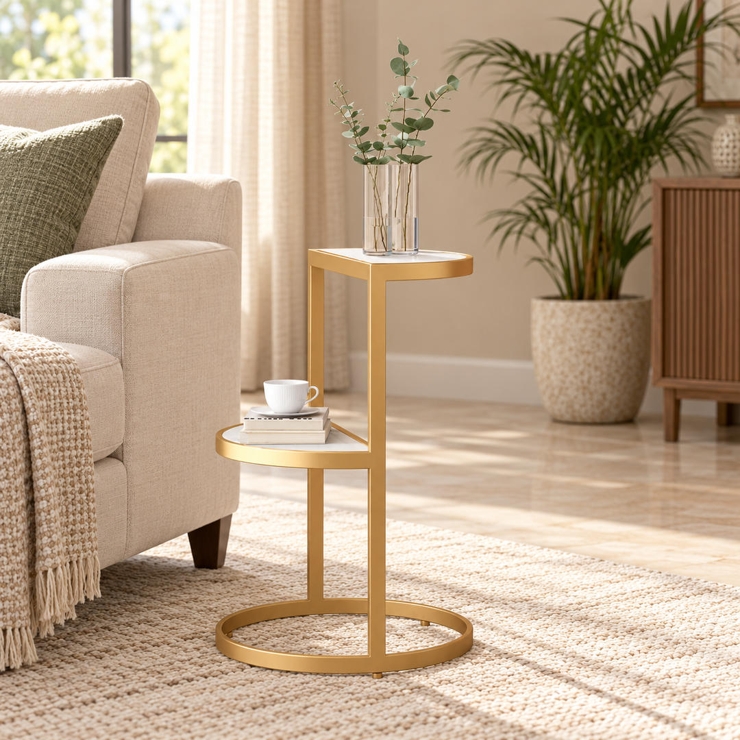 White and gold Tabouret two-tier side table beside a sofa in warm natural daylight