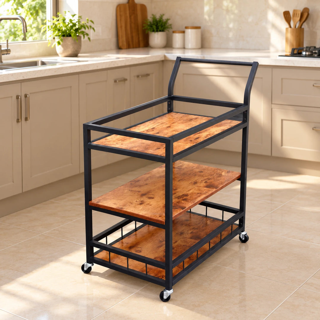 Tage kitchen trolley with three wood-effect shelves, black frame and caster wheels in a sunlit kitchen