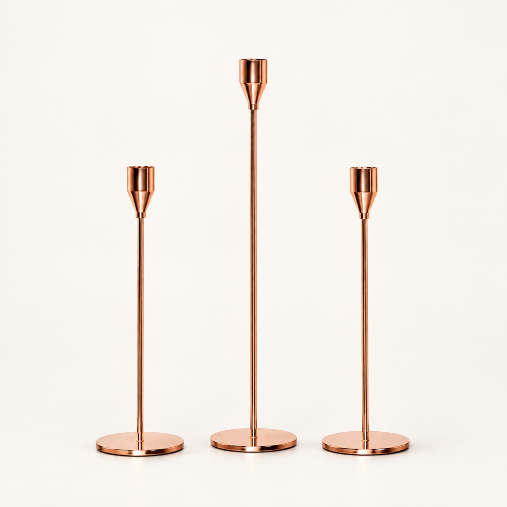 Three rose gold stick candle holders in different heights on white background