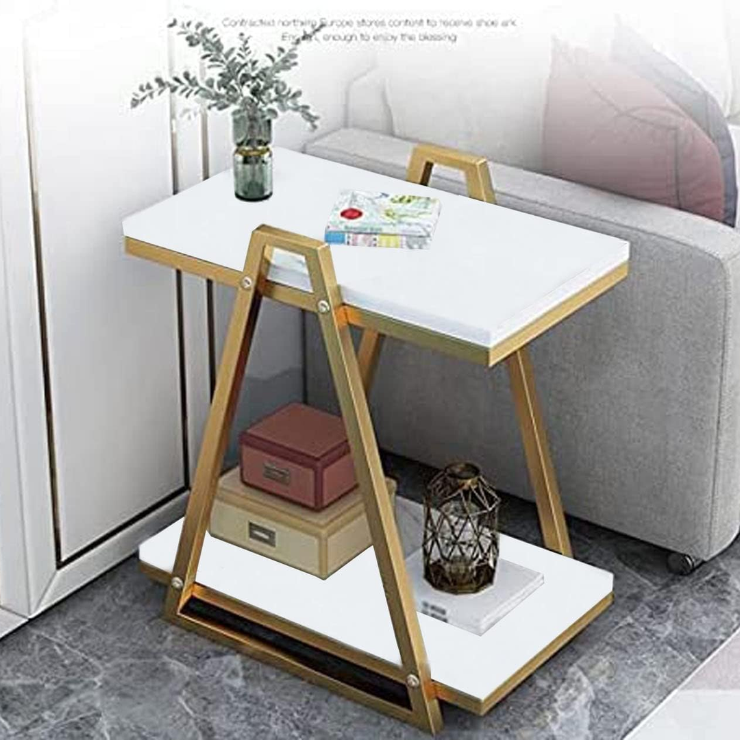 White marble-look side table with gold triangular frame beside grey sofa