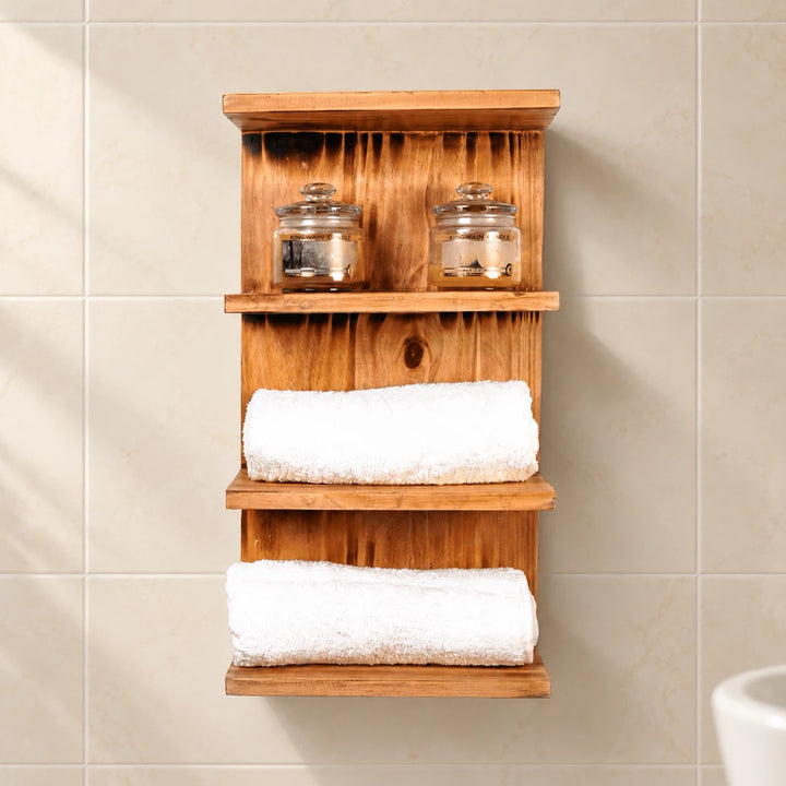 Wooden three-tier bathroom shelf with towels and candle jars