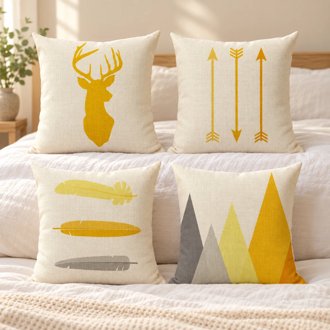 Four Tulsa cushion covers with yellow and grey deer, arrow, feather and triangle prints on bedding