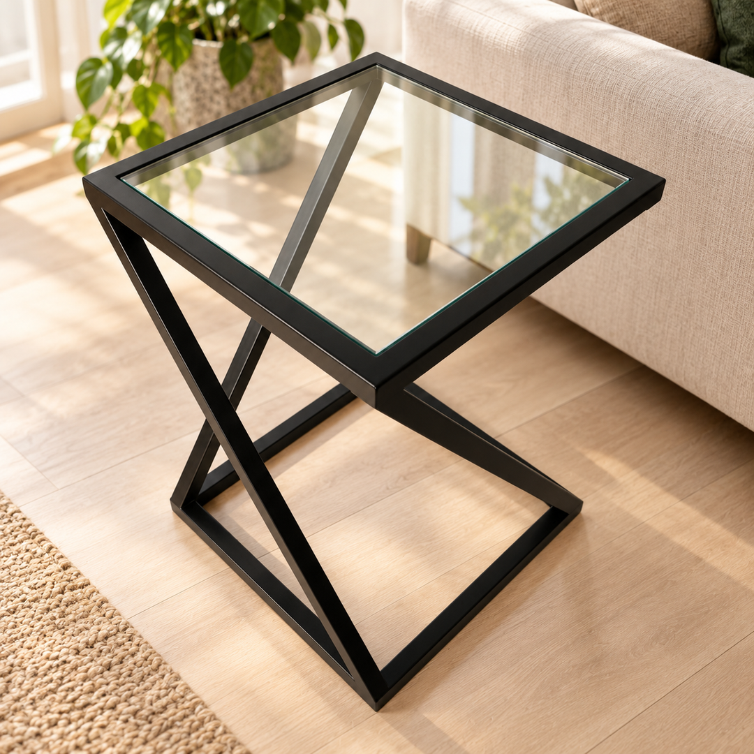 Twisted clear glass side table with black geometric frame beside a sofa