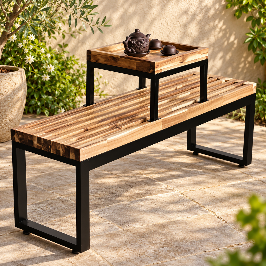 Slatted wood garden bench with raised tea table and black metal frame on a sunny planted patio
