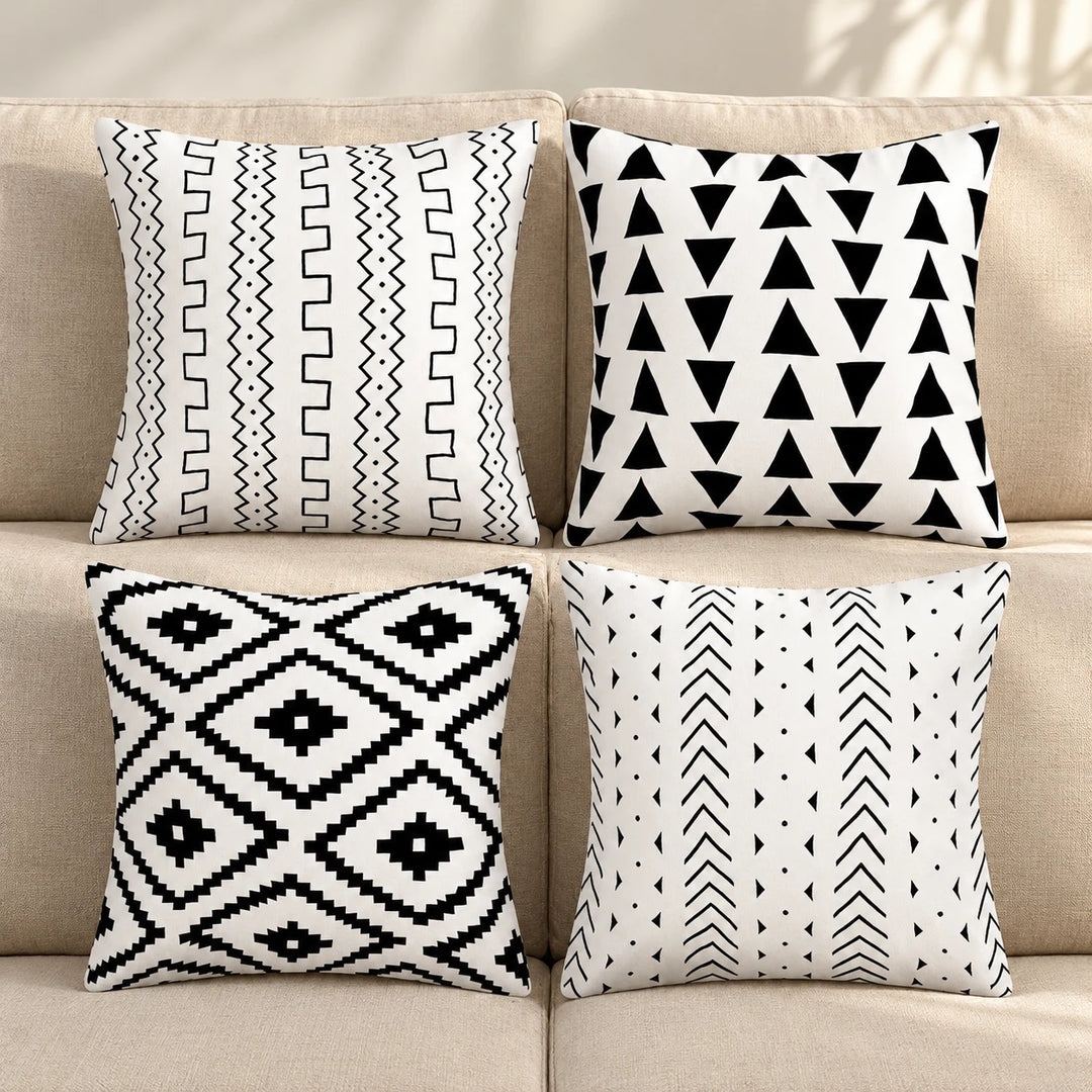 Four Vionara black-and-white printed cushion covers on a neutral sofa