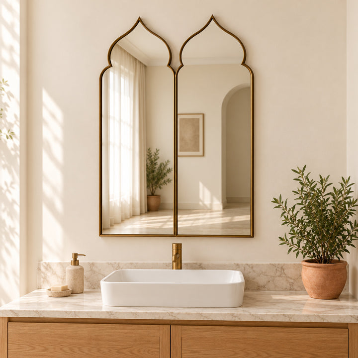 Moorish double arch mirror above a single basin with marble countertop and greenery. Digitally styled visualization.