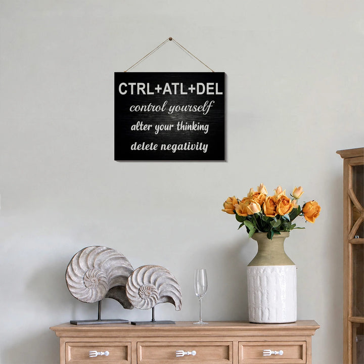 Black CTRL ATL DEL motivational wall plaque above a wooden sideboard with shell ornaments and flowers