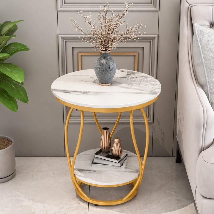 Gilded two-tier round white marble-effect side table with warm ochre powder-coated frame beside sofa