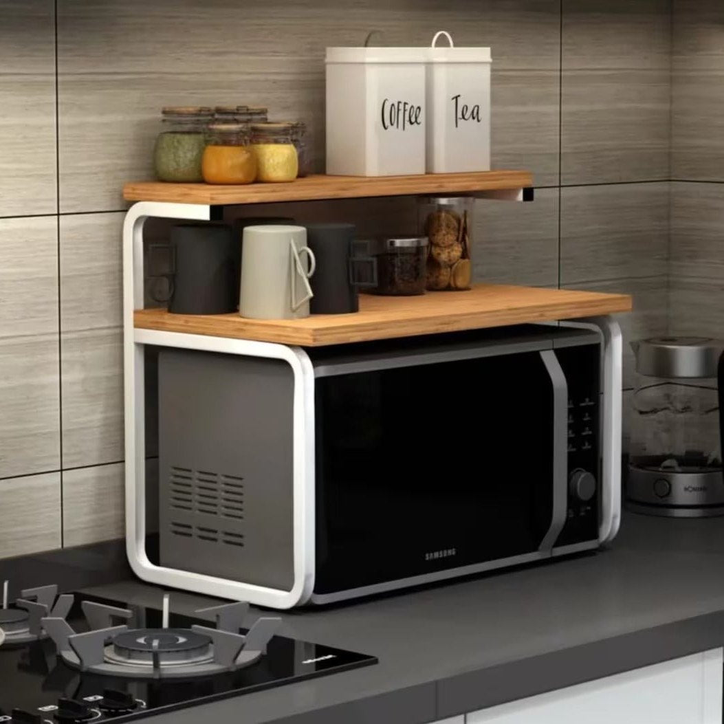Wood and white metal counter top rack over microwave with jars on top shelf