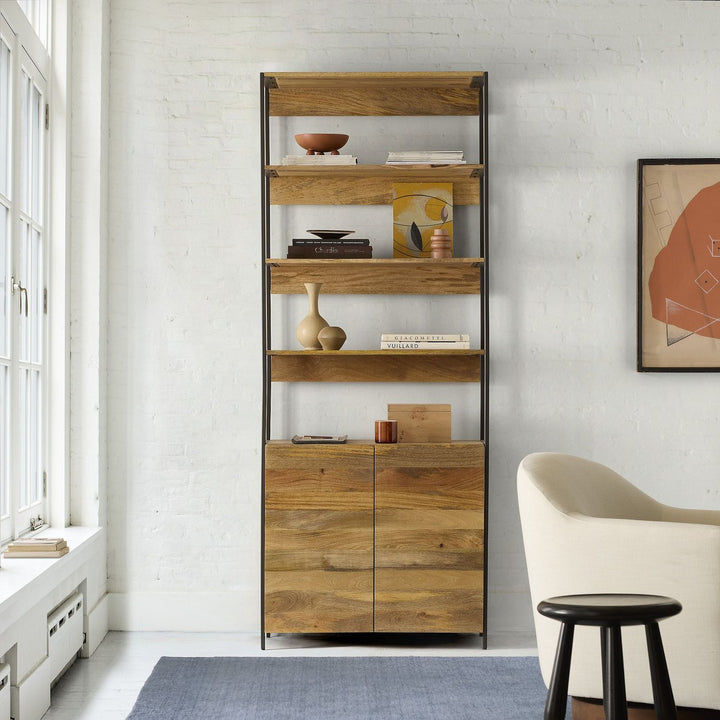 Tall bookcase organizer rack with open shelves and wooden cabinet beside window
