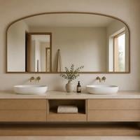 Wide arched top bathroom mirror with a wooden frame above a double basin vanity unit